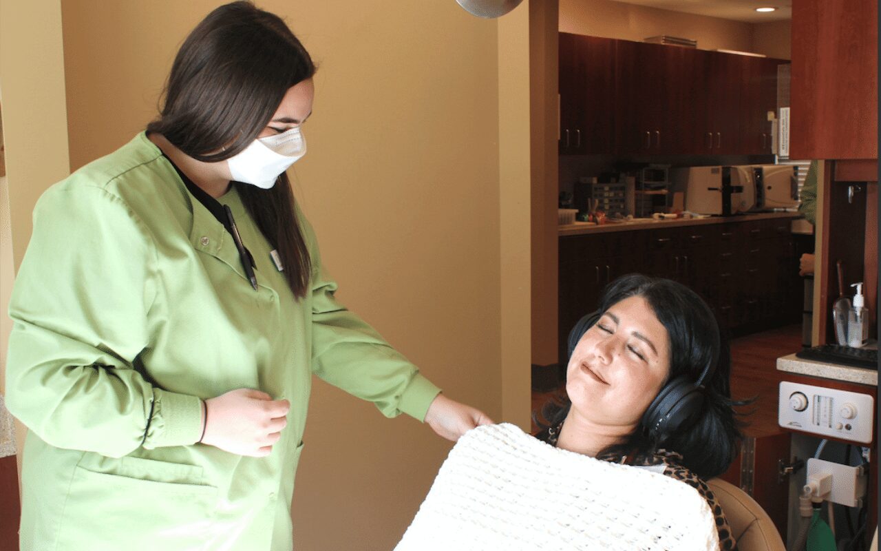 Healthcare worker comforting a patient in a clinic.