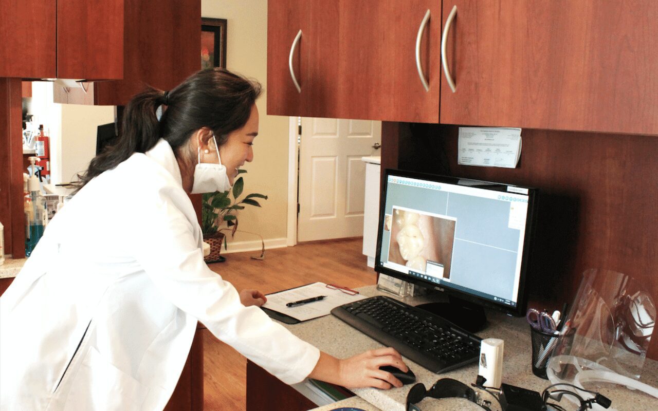 A doctor reviewing a patient's X-ray on a computer screen.