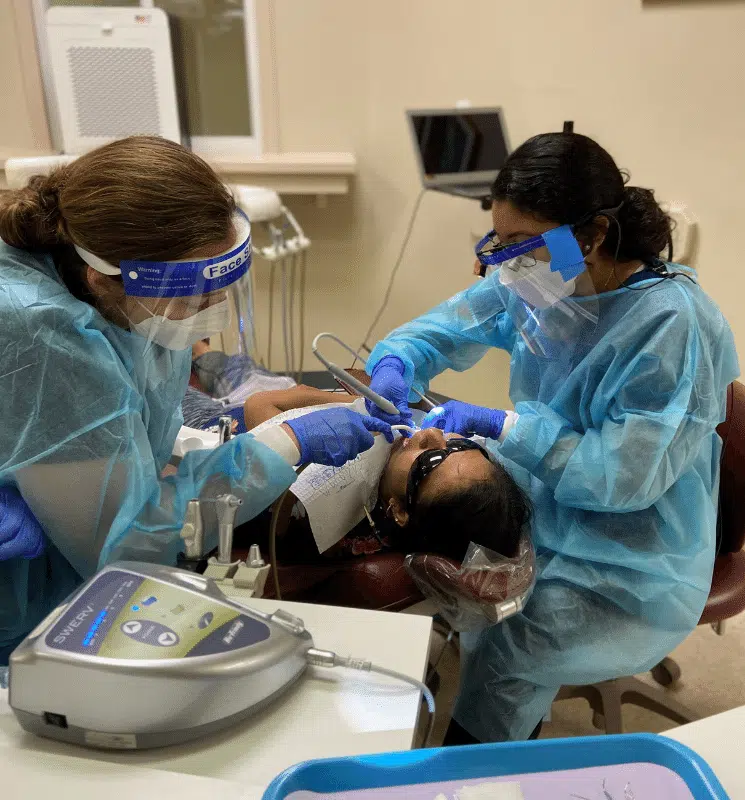 Dental procedure with two clinicians in PPE