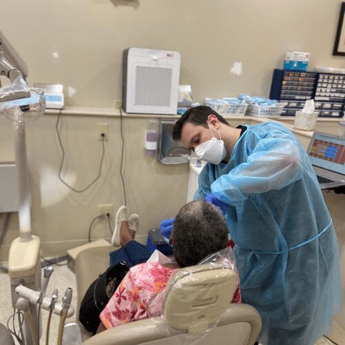 Dentist examining patient in clinic room